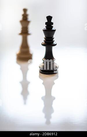 Schwarzer König im Fokus und weißer König im Hintergrund. Fokus auf Vordergrund. Geringe Schärfentiefe. Vertikal. Stockfoto