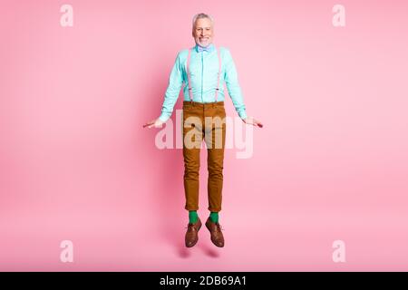 In voller Länge Körpergröße Foto von glücklich lächelnden alten Mann Lachend tragen Hosenträger bowtie Springen isoliert auf rosa Farbe Hintergrund Stockfoto