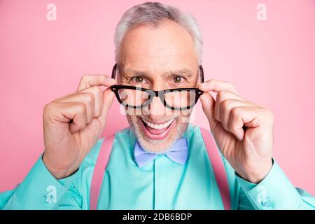 Nahaufnahme Kopffoto des glücklichen lustigen alten Mannes, der die Brille berührt Lächelnd lachend isoliert auf rosa Hintergrund Stockfoto