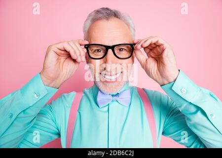 Nahaufnahme Kopfschuss Foto von Mann tragen Brillen Bowtie Hosenträger hell shirt lächelnd isoliert auf rosa Hintergrund Stockfoto