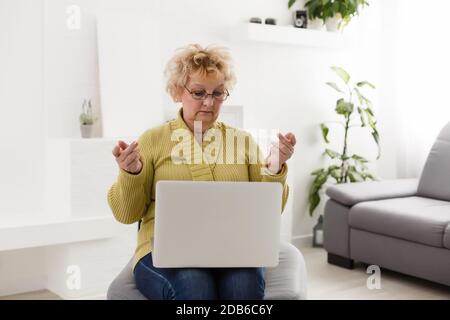 Schockiert mittleren Alters reife Frau Gefühl gestresst Lesen unglaubliche Online-Nachrichten überrascht ältere alte Dame Blick auf Laptop überrascht durch unerwartete Stockfoto