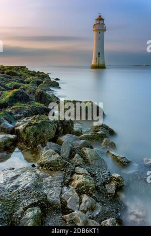 Neuer Leuchtturm von Brighton an der Küste von Merseyside mit Felsen im Vordergrund. Stockfoto