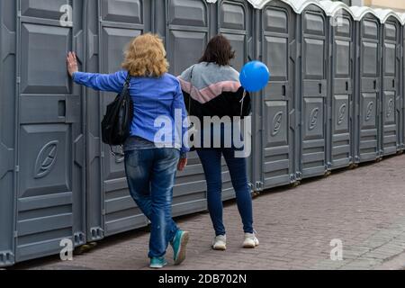 Blick von der Rückseite von zwei Frauen, die an einem stehen Reihe von Toiletten Stockfoto