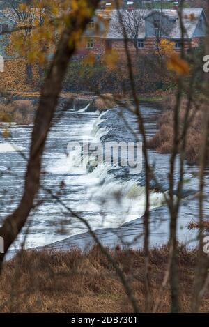 Ein breiter Flusswasserfall mit kleinen Wasserfällen, umgeben vom Herbst Farben Stockfoto