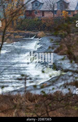 Ein breiter Flusswasserfall mit kleinen Wasserfällen, umgeben vom Herbst Farben Stockfoto