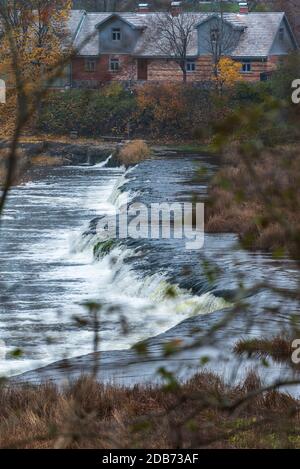 Ein breiter Flusswasserfall mit kleinen Wasserfällen, umgeben vom Herbst Farben Stockfoto