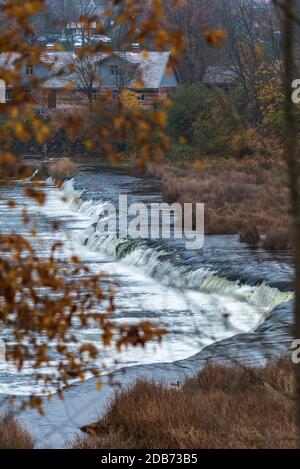 Ein breiter Flusswasserfall mit kleinen Wasserfällen, umgeben vom Herbst Farben Stockfoto