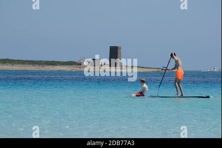 Zwei Freunde schwimmen auf Stand Up Paddle Board im türkisfarbenen Wasser vor dem La Pelosa Strand. .Wassersport, aktiver Lebensstil Stockfoto