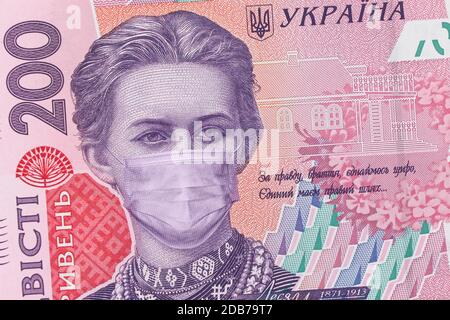 200 Griwna Banknote mit Lesya Ukrainka in einer medizinischen Maske, horizontal. Die Ukraine ist von einer Wirtschaftskrise betroffen. Ukrainisches Geld, Coronavirus Konzept, Mo Stockfoto