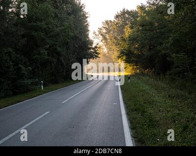 Die Straße, die an der Biegung durch Sonnenlicht beleuchtet wird. Sie vertreten die Inspiration, Gottes Erscheinungen, Aufklärung Stockfoto