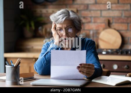 Unglücklich reifen Tragen einer Brille lesen schlechte Nachrichten in Brief Stockfoto