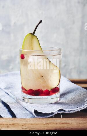 Kaltes Getränk mit Birne und Preiselbeeren auf Holzgrund. Birnencocktail. Stockfoto