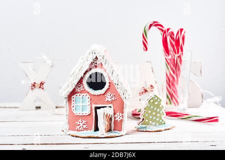 Lebkuchenhaus auf einem weißen festlichen Weihnachtshintergrund. Stockfoto