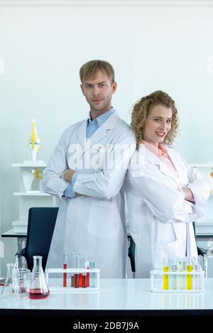 Zwei Wissenschaftler standen selbstbewusst mit gefalteten Armen, bevor das Experiment begann. Arbeitsatmosphäre in einem wissenschaftlichen Labor. Stockfoto