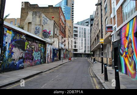 Bacon Street, Spitalfields während der ersten UK-Sperre im Jahr 2020, mit einer Mischung aus sehr neuer & alter Architektur & atemberaubender Street Art & rauer Graffiti. Stockfoto