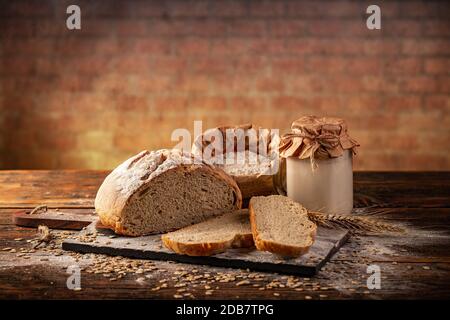 Aktiv-Weizen-Sauerteigsstarter in Glasbecher mit Brot Stockfoto