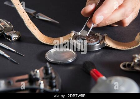 Der Austausch einer Uhrenbatterie mit uhrmacher Tools Stockfoto