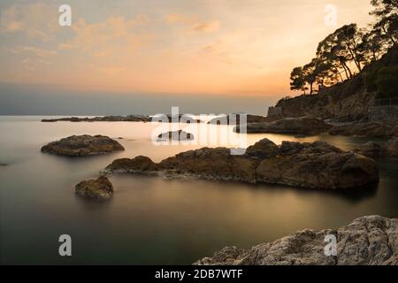 Detail der Felsen im Meer der ​​Tellaro während der Goldenen Stunde der Sonnenuntergang mit Wolken am Horizont Stockfoto