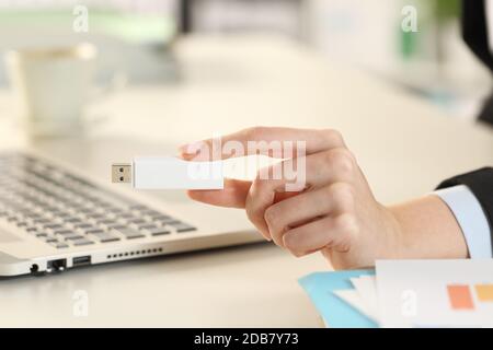 Nahaufnahme der Geschäftsfrau mit Laptop-Hand, die einen hängenden Stick im Büro zeigt Stockfoto