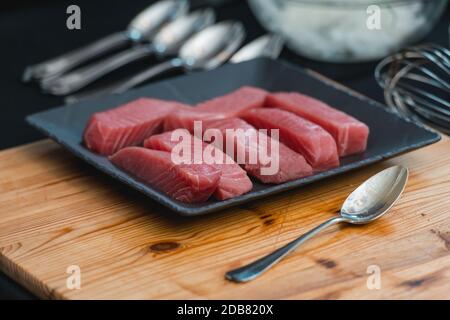 Rohes Thunfischfiletsteak auf einer schwarzen Keramikplatte Stockfoto