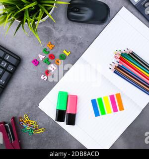 Das Layout von Schulmaterial auf einem dunkelgrauen Hintergrund. Die Aussicht von oben. Zurück zu Schule. Flach Stockfoto