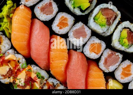 Farbenfrohe, frische Sushi-Rolle auf einem schwarzen Tablett. Japanische Küche. Draufsicht. Stockfoto