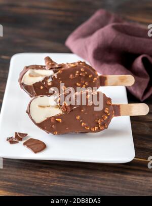 Schokoladenbedeckter Vanilleeis auf der weißen Platte Stockfoto