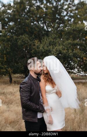 Porträt einer Braut und eines Bräutigams, die auf einem Feld stehen, Russland Stockfoto