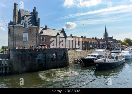 Die Hafenspringer von Veere, Kinder auf der Suche nach Abenteuer im historischen Hafen auf der Halbinsel Walcheren in Südholland. Stockfoto