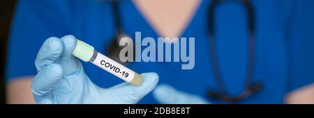 Reagenzglas in der Hand eines Laboranten mit einer Probe des Coronavirus Covid-19, eines tödlichen globalen Pandemiekonzepts Stockfoto