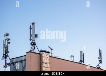 Mobilfunkrepeater auf dem Dach eines Hochhauses gegen den blauen Himmel. Speicherplatz kopieren Stockfoto