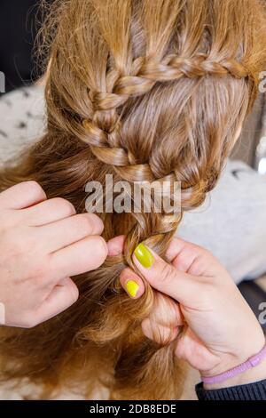 Professionelle Flechten von Zöpfen durch einen Meisterfriseur in einem Schönheitssalon. Das Konzept der Haarpflege. Stockfoto