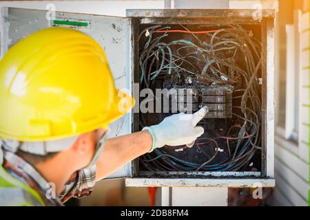 Elektriker, der eine Zentrale nach einem Elektrobrand überprüft, Thailand Stockfoto