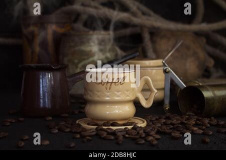 Vintage Kaffeetasse, Topf, Schleifer mit Kaffeebohnen auf einem rustikalen Holzmöbeln Oberfläche Stockfoto