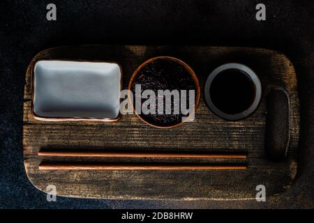 Overhead-Ansicht einer asiatischen Platzeinstellung auf einem Tisch Mit schwarzem Reis und Sojasauce Stockfoto