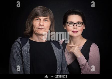 Reifer Mann und Frau posieren vor einer Kamera Nahaufnahme vor dunklem Hintergrund Stockfoto