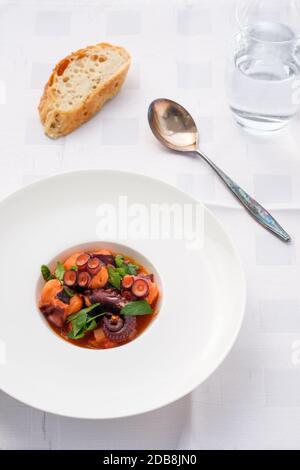 Teller mit geschmorten Oktops Tomatensauce und Petersilie in der Oberseite Anzeigen Stockfoto