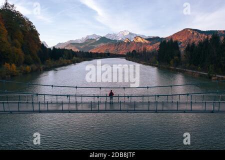 Luftaufnahme des Menschen, der bei Sonnenuntergang auf der Brücke über die Salzach steht, Salzburg, Österreich Stockfoto