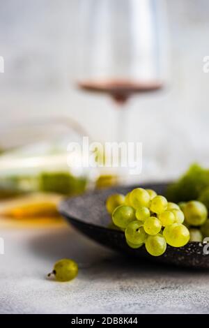 Auf einem Teller liegen Gläser Rot- und Weißwein Mit grünen Trauben Stockfoto