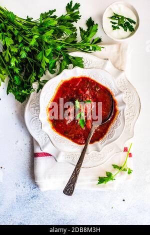 Blick von oben auf eine Schüssel mit traditioneller ukrainischer Rote Beete-Suppe Mit Sauerrahm Stockfoto