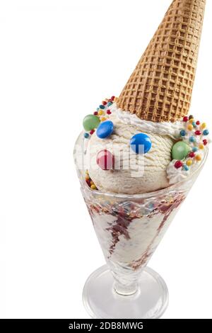 Lustige Eiscreme Clown aus konischem Glas aus weißer Schaufel, bunter Knopfschokolade und Waffelkegel als Hut, in Nahaufnahme gegen weißen Rücken Stockfoto