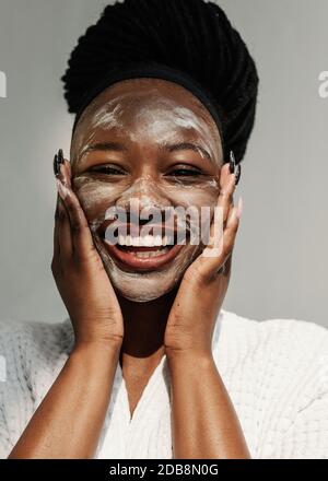 Porträt einer lächelnden Frau mit Gesichtsmaske Stockfoto