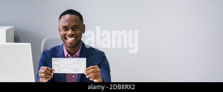 Nahaufnahme EINES lächelnden Geschäftsmannes, der den Firmencheck zeigt Stockfoto