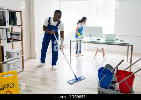 Junge männliche und weibliche Reiniger Reinigung Büro Stockfoto