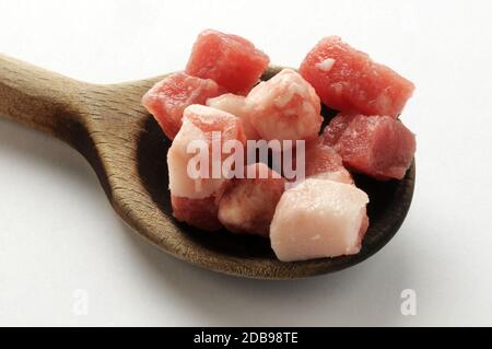 Rohe Schinkenwürfel auf Löffel Stockfoto