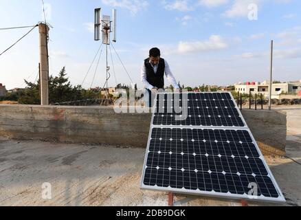 Sweida, Syrien. November 2020. Diaa Abdullah, ein 31-jähriger Ingenieur, steht am 2. November 2020 in der Nähe einer Windturbine und Solarzellen auf dem Dach seines Hauses in der Provinz Sweida im Süden Syriens. Quelle: Ammar Safarjalani/Xinhua/Alamy Live News Stockfoto