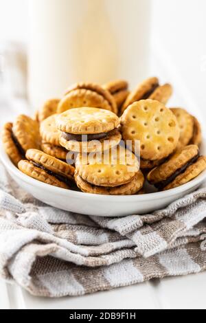 Mini-Creme Sandwich-Kekse in Schüssel auf weißem Tisch. Stockfoto