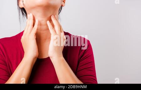 Die schöne asiatische Frau, die ihr den juckenden Hals auf weißem Hintergrund mit Copy-Space, Medical and Healthcare Concept kratzt Stockfoto