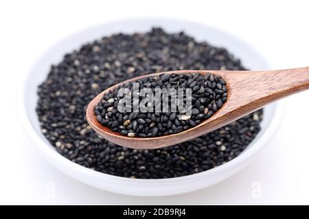 Schwarze Sesamsamen mit Holzlöffel. Sesamsamen in einer Schüssel Stockfoto