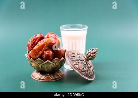 Ramadan, Datteln in goldener Schüssel, Milch, arabian Aladdin goldener Lampe Vintage-Stil auf schwarz-grünem Hintergrund Stockfoto